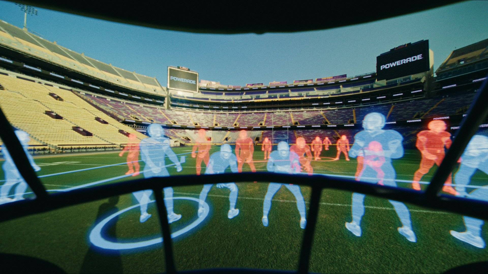 Powerade x LSU: a holographic play simulation hovers over the field as the quarterback reaches into it. Curved HUD panes, blue and red player holograms, a circular play marker.